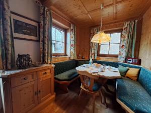 een eetkamer in een hut met een tafel en banken bij Apartment Bergpanorama by Interhome in Oberau