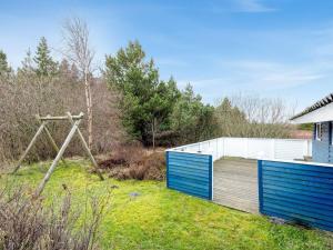 un jardín con una valla de madera y un columpio en Holiday Home Elpida - 2km from the sea in Western Jutland by Interhome, en Lakolk