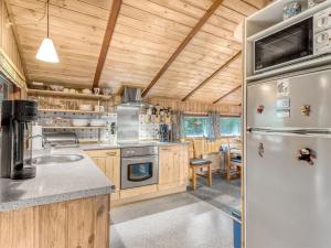 cocina con nevera, fregadero y mesa en Holiday Home Elpida - 2km from the sea in Western Jutland by Interhome, en Lakolk
