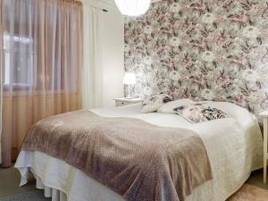 1 dormitorio con 1 cama y papel pintado con motivos florales en Holiday Home Saajola by Interhome, en Leppäjärvi
