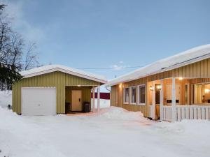 a house with a garage in the snow at Holiday Home Saajola by Interhome in Leppäjärvi