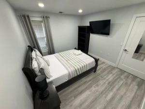 a bedroom with a bed and a television in it at The Elegant Suite - 2BR with Great Amenities in Paterson