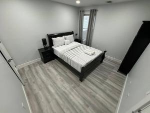um quarto com uma cama com lençóis brancos e almofadas em The Elegant Suite - 2BR with Great Amenities em Paterson