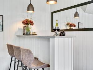 un bar en una habitación con 2 sillas y un espejo en Holiday Home Jasna - 470m from the sea in Funen by Interhome en Otterup