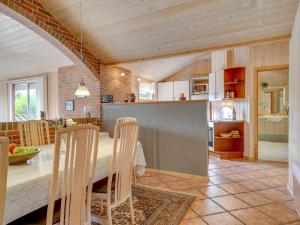 uma cozinha e sala de jantar com mesa e cadeiras em Holiday Home Svenger - 800m from the sea in NW Jutland by Interhome em Fjerritslev