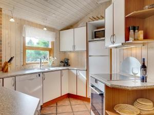 a kitchen with white cabinets and a sink at Holiday Home Svenger - 800m from the sea in NW Jutland by Interhome in Fjerritslev