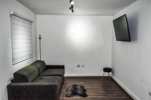 un soggiorno con divano e TV a schermo piatto di Nomad Casa en la mejor ubicación a Hermosillo