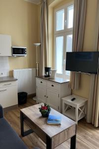 een woonkamer met een salontafel en een flatscreen-tv bij Apartment Zinnowitzer Hof by Interhome in Zinnowitz