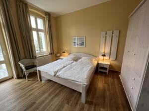 een slaapkamer met een wit bed en 2 ramen bij Apartment Zinnowitzer Hof by Interhome in Zinnowitz