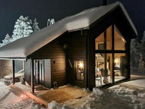 a log cabin in the snow at night at Holiday Home Levin kuiskaus by Interhome in Sirkka