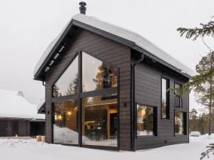 a house with large windows in the snow at Holiday Home Levin kuiskaus by Interhome in Sirkka
