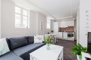 a living room with a blue couch and a kitchen at Pepes Apartment in Bergen