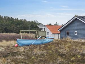 TorstedにあるHoliday Home Ani - 600m from the sea in NW Jutland by Interhomeの家の隣の野原に座る青い船