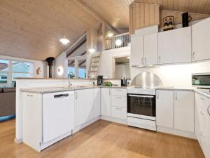 a kitchen with white cabinets and a large window at Holiday Home Ani - 600m from the sea in NW Jutland by Interhome in Torsted