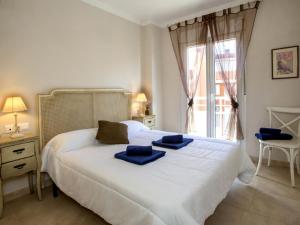 um quarto com uma cama branca e toalhas azuis em Apartment Les Portelles by Interhome em Denia