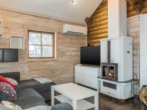 ein Wohnzimmer mit einem Sofa und einem Kamin in der Unterkunft Holiday Home Puljunharju by Interhome 