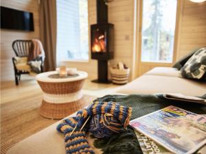 a living room with a bed and a fireplace at Holiday Home Honka b by Interhome in Napapiiri