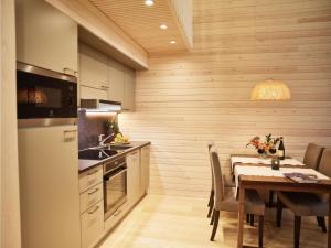 a kitchen with a table and a dining room at Holiday Home Honka b by Interhome in Napapiiri