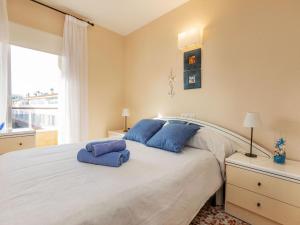 a bedroom with a large white bed with blue pillows at Apartment Venecia-2 by Interhome in Platja  d'Aro