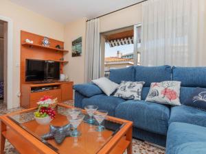a living room with a blue couch and a table at Apartment Venecia-2 by Interhome in Platja  d'Aro