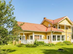 uma grande casa amarela com um telhado vermelho em Holiday Home Grand villa kemijoki by Interhome em Kupari