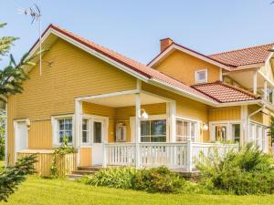 ein gelbes Haus mit einer weißen Veranda in der Unterkunft Holiday Home Grand villa kemijoki by Interhome in Kupari