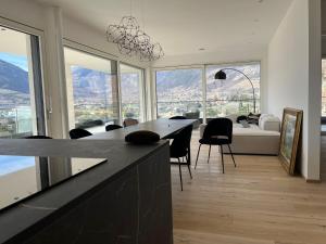 a living room with a table and some chairs and windows at The Hills in Merano