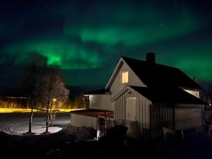 an image of a house under the northern lights at Drengstua in Kvaløya