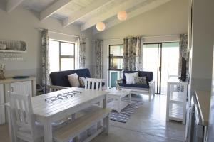 a kitchen and living room with a table and chairs at Osler Place Self-Catering in Stilbaai