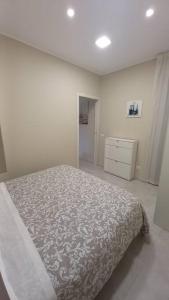 ein weißes Schlafzimmer mit einem Bett und einer Kommode in der Unterkunft Casa vacanza Al Cortiletto in Sortino