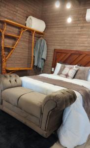 a bedroom with two beds and a couch in it at Sítio Aconchego dos Canyons in Praia Grande