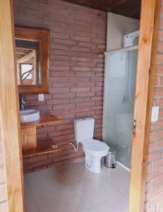 a bathroom with a toilet and a sink at Sítio Aconchego dos Canyons in Praia Grande