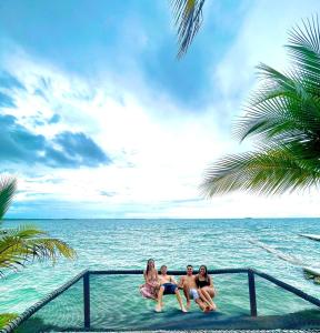 グランデ島にあるHotel Cocoliso Island Resortの三人の女が海の近くの水に座っている