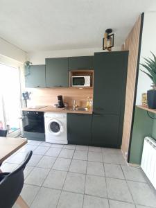 una cocina con lavadora y microondas en L'Emeraude, les pieds dans l'eau, en Saint-Hilaire-de-Riez