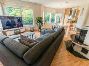 a living room with a large couch and a tv at Holiday Home Villa jokiranta by Interhome in Eurajoki