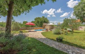 a garden with a pool and a red umbrella at House Soul in Oklaj