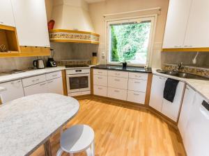 a kitchen with white cabinets and a wooden floor at Holiday Home Villa jokiranta by Interhome in Eurajoki +22 photos