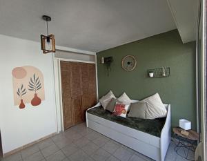 Un dormitorio con una cama con una pared verde. en L'Emeraude, les pieds dans l'eau, en Saint-Hilaire-de-Riez