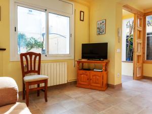 a living room with a television and a chair at Holiday Home Can Can Grau by Interhome in Platja  d'Aro +19 photos