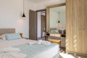 1 dormitorio con cama con espejo y lavamanos en ARETI LUXURY APARTMENTS en Georgioupolis