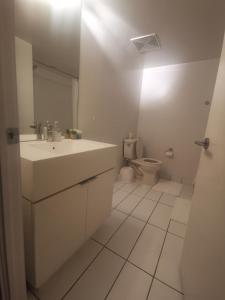 a white bathroom with a sink and a toilet at Neat open concept condo Downtown Toronto in Toronto