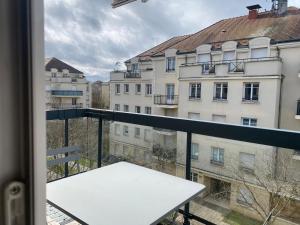 a balcony with a white table and a building at Mickey House 6 pers 10 Min Disney & 30Min Paris in Bussy-Saint-Georges