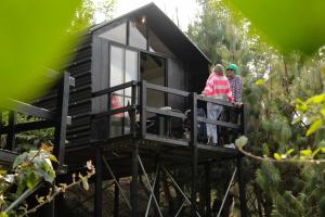 two people standing on the balcony of a tiny house at Tiny House La Silleta in Medellín