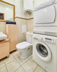 a bathroom with a toilet and a washing machine at River view Cathedral Apartment in Vilnius