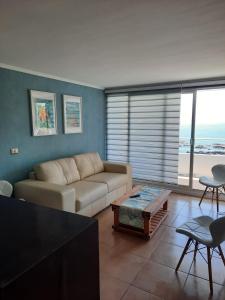 a living room with a couch and a table at Depto equipado frente al mar. Hemosa vista in Concón