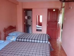 een slaapkamer met een bed en een rode deur bij Villa hospedaje in Huaraz
