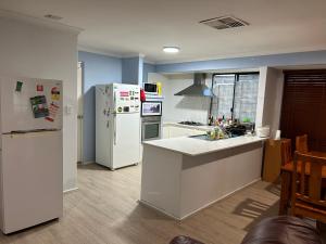 una cucina con frigorifero e piano di lavoro di double room share bathroom and kitchen a Perth