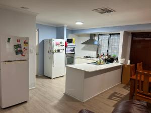 a kitchen with a refrigerator and a counter top at double room share bathroom and kitchen in Perth