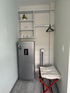 Habitación pequeña con nevera y taburete. en Constanza Lofts Executives en Zapopan Jalisco, en Guadalajara