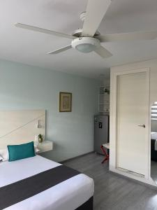 een slaapkamer met een bed en een plafondventilator bij Constanza Lofts Executives en Zapopan Jalisco in Guadalajara